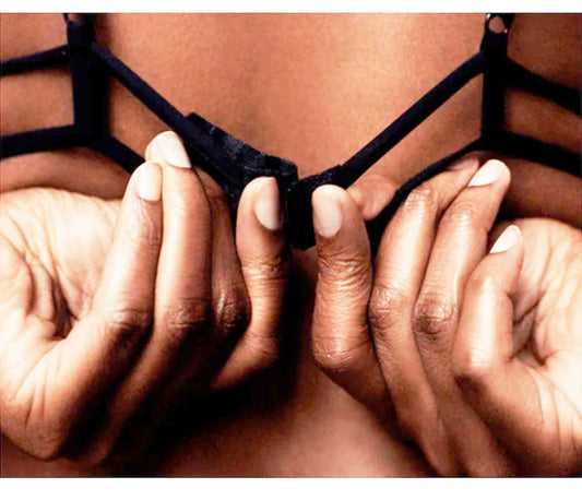 A Faceless Woman Fiddling with the Back Closure on A Black Bra