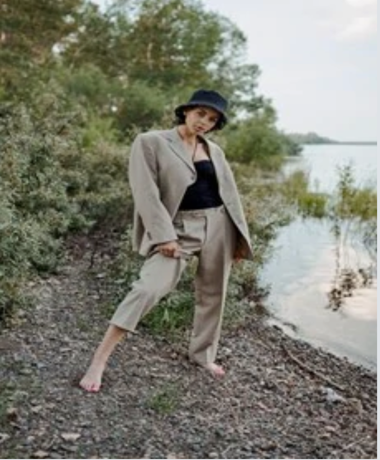 Woman in a Hat and Bodysuit Paired with an Oversized Blazer and Wide-Legged Pants